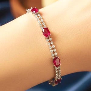 Puede incluir: Una taza de cerámica blanca con un asa negra y el texto "But First, Coffee" en negrita negra. La taza se encuentra sobre un fondo neutro, resaltando su diseño simple.