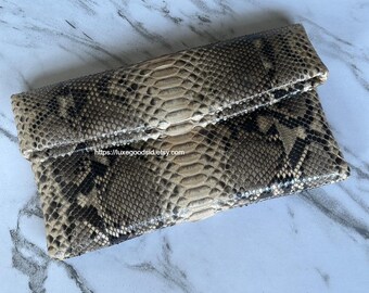 Bolso de mano de piel de pitón beige: Bolso tipo sobre con solapa y diseño de piel de serpiente.