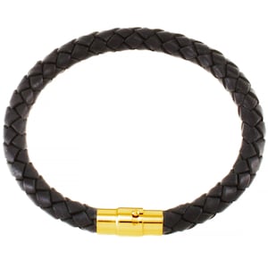 Könnte beinhalten: Ein dunkelbraunes geflochtenes Lederarmband mit einem goldfarbenen Magnetverschluss. Das Armband ist kreisförmig und scheint aus geflochtenen Ledersträngen zu bestehen. Der Verschluss ist rechteckig und hat einen kleinen, runden Knopf.