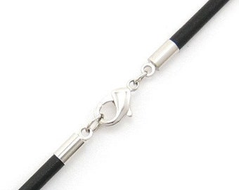 May include: Close-up of a black cord necklace with a silver-colored clasp and end caps. The clasp is a lobster claw style, and the end caps are cylindrical. The necklace is against a white background.