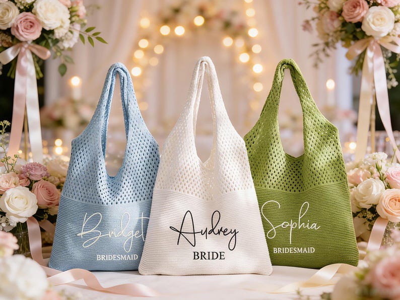 May include: Three knitted tote bags in pastel shades: light blue, white, and green. The light blue bag says "Bridget, Bridesmaid". The white bag says "Audrey, Bride". The green bag says "Sophia, Bridesmaid". Perfect for wedding gifts.