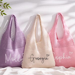 May include: Three personalised tote bags in lavender, cream, and pink. Each bag features a knitted mesh upper and a solid bottom with a name in script. The lavender bag says "Molly", the cream bag says "Georgia", and the pink bag says "Sophia".