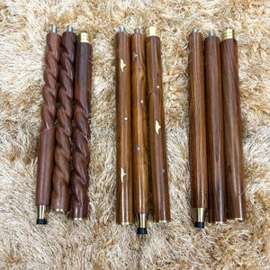 May include: Three sets of wooden furniture legs in varying designs. The legs are a rich brown color with brass-colored accents. One set features a twisted design, while the others are smooth or have natural wood grain.