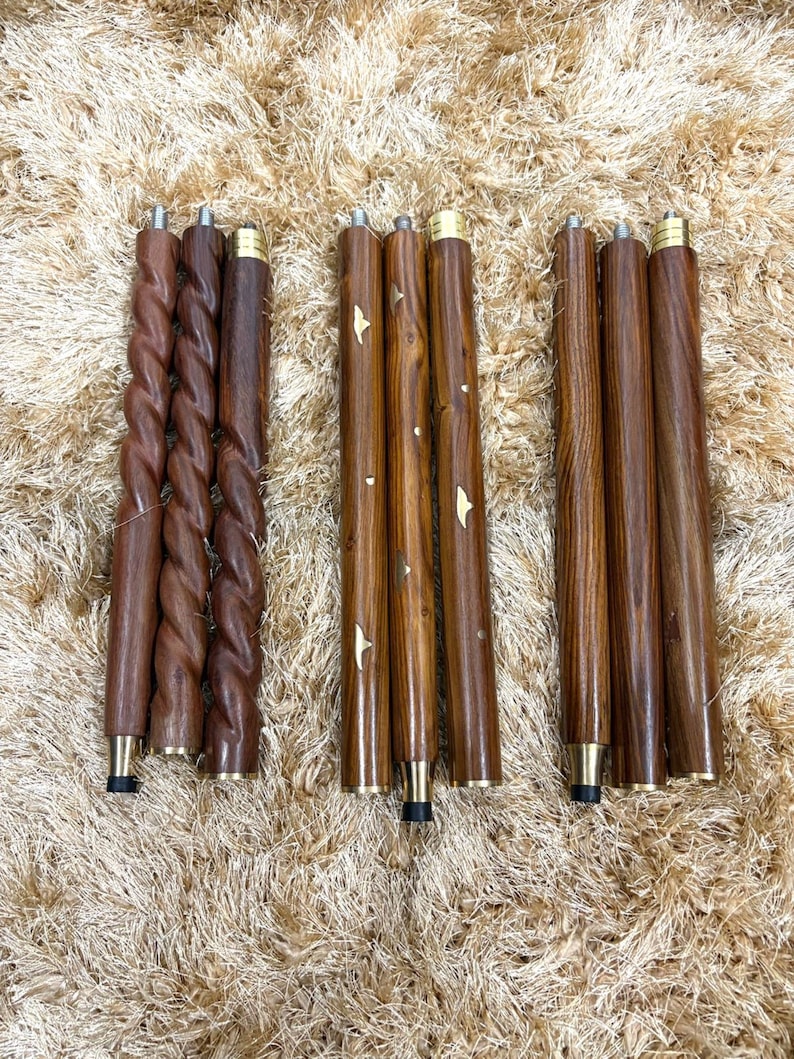 May include: Three sets of wooden furniture legs in varying designs. The legs are a rich brown color with brass-colored accents. One set features a twisted design, while the others are smooth or have natural wood grain.