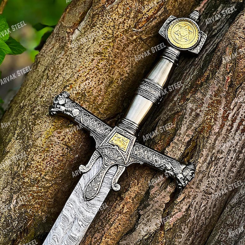 May include: A detailed sword with a silver blade and handle, featuring intricate engravings and gold accents. The hilt has a star emblem. The text "ARVAK STEEL" is visible on the sword.