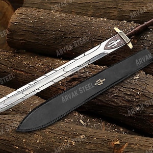 May include: A silver sword with a geometric design on the blade, a brown leather-wrapped handle, and a gold-colored hilt. The sword rests on a pile of logs next to a black leather sheath with a gold trident emblem. The text "ARVAK STEEL" is visible.