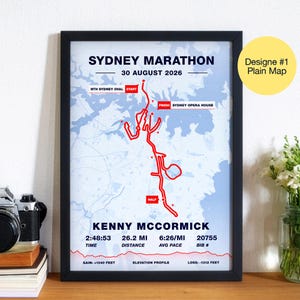 May include: Framed print of the Sydney Marathon, dated August 30, 2026, featuring a red route map. The print includes runner Kenny McCormick's time, distance of 26.2 miles, average pace, and bib number. The design is labeled "Plain Map."