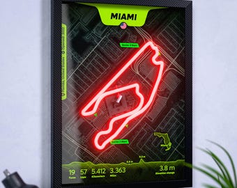Könnte beinhalten: Ein gerahmtes Wandbild mit einer leuchtend roten Neon-Kontur der Formel-1-Rennstrecke in Miami auf dunklem Kartenhintergrund. Der Druck enthält den Text MIAMI, Florida, United States, 19 Turns, 57 Laps, 5,412 Kilometer und 3,363 Meilen.