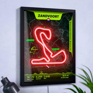 May include: A framed wall art print of the Zandvoort race track in the Netherlands. The track layout is highlighted in bright red against a dark map background with neon green accents. Text includes Zandvoort, 14 turns, 72 laps, 4.259 kilometers, 2.646 miles, and 8.9 meters elevation change.