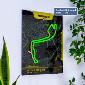 May include: An unframed A3 poster featuring a dark map of the Monaco Grand Prix circuit. A bright neon green line traces the track layout over the street grid. Text includes MONACO, 19 turns, 78 laps, 3.337 kilometers, 2.074 miles, and 42 m elevation change.