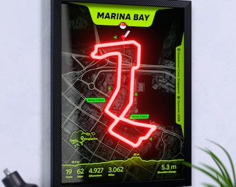 Könnte beinhalten: Ein gerahmter Wandkunstdruck der Marina Bay Rennstrecke in Singapur. Die Karte zeigt einen leuchtend roten Streckenverlauf über einem dunkelgrauen Stadtplan mit hellgrünen Akzenten, Textbeschriftungen und technischen Daten.