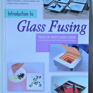 May include: Book cover with the title "Introduction to Glass Fusing" and a subtitle "Project-by-Project Guided Lessons: A Comprehensive Guide to Glass Fusing Techniques". The cover features a colorful image of a kiln and a variety of glass fusing projects.