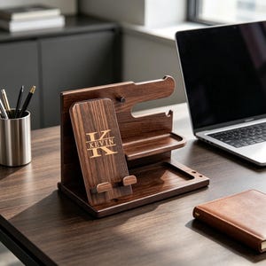 May include: A dark brown wooden desk organizer with multiple compartments for a phone, pens, and other accessories. The organizer has the name "KEVIN" and the letter "K" engraved on the front.