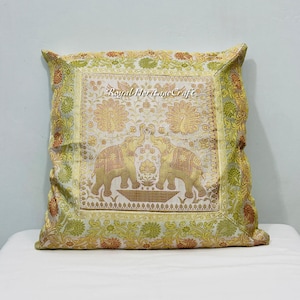 May include: A square cushion with an elaborate design. The cushion features two elephants and a gold and green floral pattern. The text "Royal Heritage Craft" is visible.