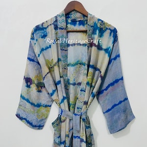 May include: A blue and white patterned robe with long sleeves and a matching belt. The robe has a tie-dye effect with accents of gold and purple. The text "Royal Heritage Craft" is visible on the robe.