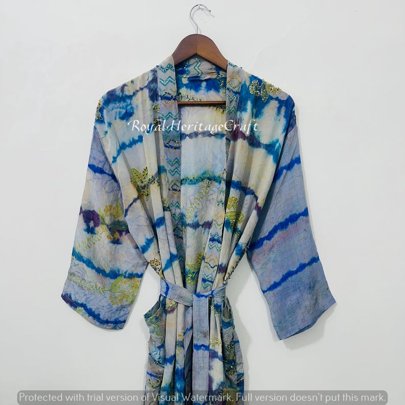 May include: A blue and white patterned robe with long sleeves and a matching belt. The robe has a tie-dye effect with accents of gold and purple. The text "Royal Heritage Craft" is visible on the robe.