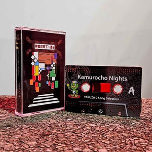 May include: Two cassette tapes. One is a clear case with a black cover featuring colorful geometric shapes and Japanese text. The other is black with the text "Kamurocho Nights" and a cartoon character. "Yakuza O Song Selection" is also printed.