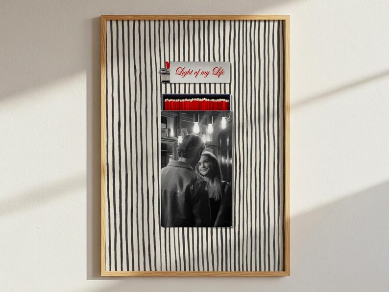 May include: Framed art print featuring a black and white photograph of a couple, set within a lighter-shaped design. The top of the design reads "Light of my Life" in red script. The background has a black and white striped pattern.