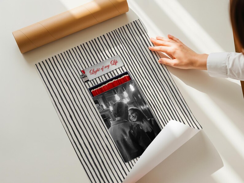 May include: A black and white striped poster with a photograph of a couple. The poster has the text "Light of my Life" on the top. A brown cardboard tube is in the background.