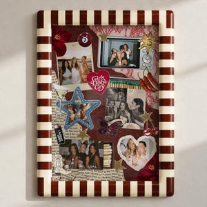 May include: A rectangular wall frame with a brown and white striped border containing a collage of photographs, a red heart sticker with the text Girls Don't Cry, a blue star cutout, a butterfly, chili peppers, a billiard ball, and gold stars.