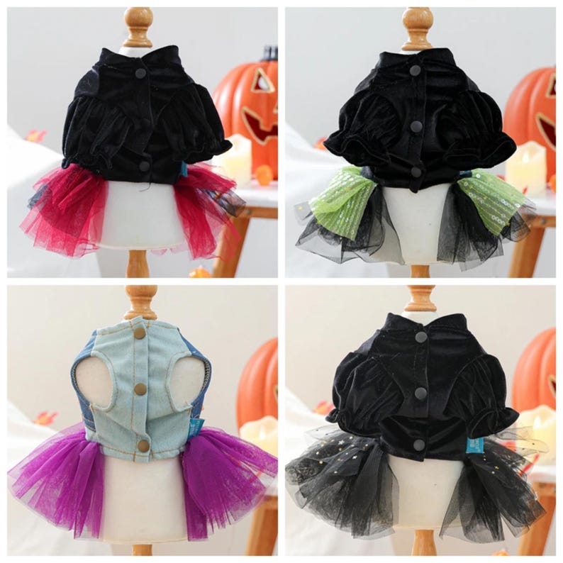 May include: A collection of four pet dresses displayed on mannequins. Three dresses feature black velvet bodices with puffed sleeves and tulle skirts in red, green, or black with stars. One dress has a light blue denim bodice and purple tulle skirt.