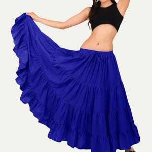 May include: A vibrant blue tiered skirt with a drawstring waist. The skirt has multiple ruffled layers and is paired with a black crop top. The skirt is full length and appears to be made of a lightweight fabric.