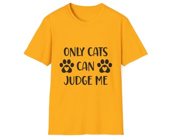 May include: Mustard yellow t-shirt with the text "ONLY CATS CAN JUDGE ME" in black. The text is arranged in three lines with paw prints on either side of the word "CAN".