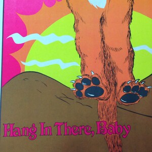 Op de afbeelding: Een vintage poster met een cartoonvos met oranje vacht, zwarte poten en een witte borst. De vos hangt ondersteboven tegen een roze lucht, gele zon en bruine grond. De tekst "Hang In There, Baby" is roze.