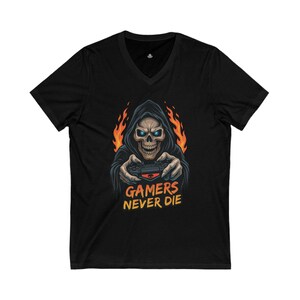 Könnte beinhalten: Schwarzes V-Ausschnitt-T-Shirt mit einem Totenkopf in einer Kapuzenrobe, der einen Gamecontroller hält, mit Flammen im Hintergrund. Der Text "GAMERS NEVER DIE" ist in Gelb und Orange gedruckt.