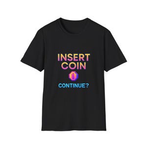 Könnte beinhalten: Schwarzes T-Shirt mit dem Text "INSERT COIN" in einem Farbverlauf aus Gelb, Orange und Pink. Darunter befindet sich eine pixelige Münzgrafik und das Wort "CONTINUE?" in Blau.