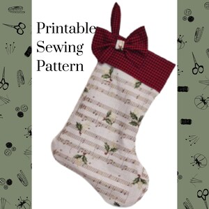 Op de afbeelding: Een kerstkous van witte stof met een muzieknotenprint en hulstbladaccenten. De boord is gemaakt van rood-zwart geblokte stof met een bijpassende strik en een ophanglus. De tekst Printable Sewing Pattern is zichtbaar op de afbeelding.