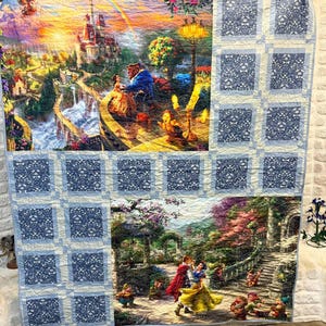 Könnte beinhalten: Eine große, farbenfrohe Steppdecke mit Szenen aus Disneys Die Schöne und das Biest und Schneewittchen. Die Steppdecke hat einen blauen Blumenrand und enthält Bilder von Biest, Belle, Schneewittchen und den Zwergen. Die Steppdecke ist eine lebendige Mischung aus Farben.