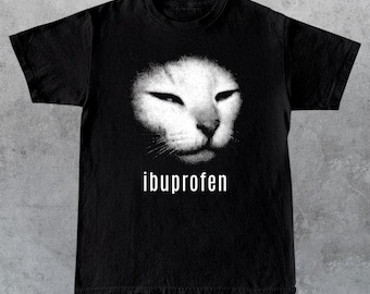 May include: Black t-shirt featuring a white cat face graphic. The word "ibuprofen" is printed in white below the cat's face. The shirt is made of a soft material.