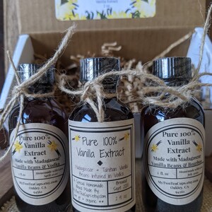 May include: Three small glass bottles with brown liquid inside. Each bottle is tied with twine and has a label that says "Pure 100% Vanilla Extract". The labels also list the ingredients, brewing date, and the website "MyTwoTeaCups.etsy.com".