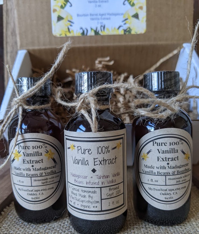 May include: Three small glass bottles with brown liquid inside. Each bottle is tied with twine and has a label that says "Pure 100% Vanilla Extract". The labels also list the ingredients, brewing date, and the website "MyTwoTeaCups.etsy.com".