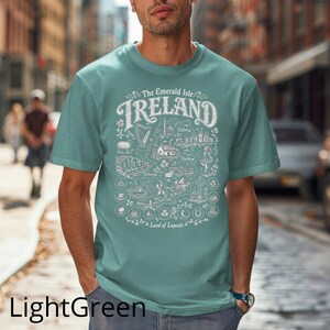 Puede incluir: Una camiseta de manga corta de color verde claro con un estampado gr&aacute;fico blanco de un mapa de Irlanda. El dise&ntilde;o incluye el texto The Emerald Isle IRELAND Land of Legends junto con varias ilustraciones de monumentos y s&iacute;mbolos irlandeses.