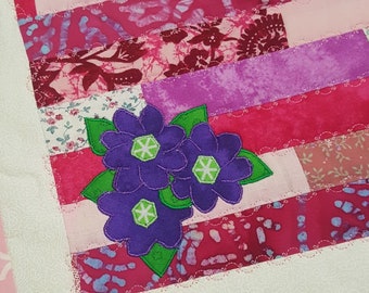 Patchwork doll quilt, placemat, table quilt, table topper, pink and white strip quilt with applique purple flowers and green leaves