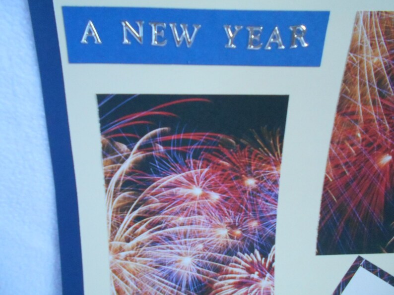 May include: A blue banner with the text "A New Year" in silver lettering, with a photo of fireworks in the background.