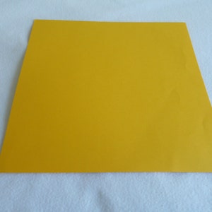 May include: A solid yellow sheet of paper.