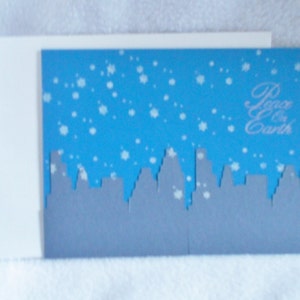 Handmade Peace on Earth Christmas card, die cut cityscape with hand stamped snowflakes, card is blank on inside for you to personalize