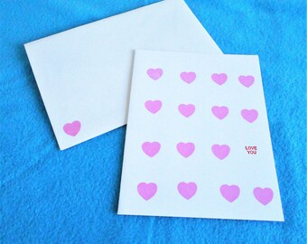 Amor que tarjeta, mano del tarjeta blanca con corazones de color rosa, sellado de tarjeta del día de San Valentín, incluye juego sobres con diseño de corazón