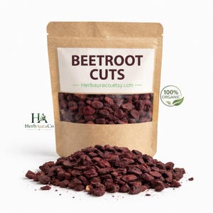 May include: A brown paper bag with a clear window filled with dried beetroot cuts. The bag has a white label with the text "BEETROOT CUTS" and "100% ORGANIC" printed on it. A pile of dried beetroot cuts is in front of the bag.