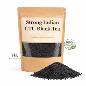 May include: A kraft paper bag filled with Strong Indian CTC Black Tea. The bag has a clear window showing the tea granules. A small pile of tea sits in front of the bag. The text "100% Organic" is on the right.