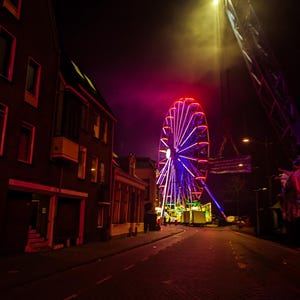 Achtung! Digitale Datei zum Download nach dem Kauf. Mysteriöse Atmosphäre einer hell erleuchteten Jahrmarktsattraktion. Spuk-Riesenrad in Kampen.