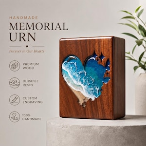 May include: A handmade memorial urn made of premium wood. The wooden box features a heart-shaped resin design depicting a beach scene with blue ocean waves and white foam. The text "Forever in Our Hearts" is visible.