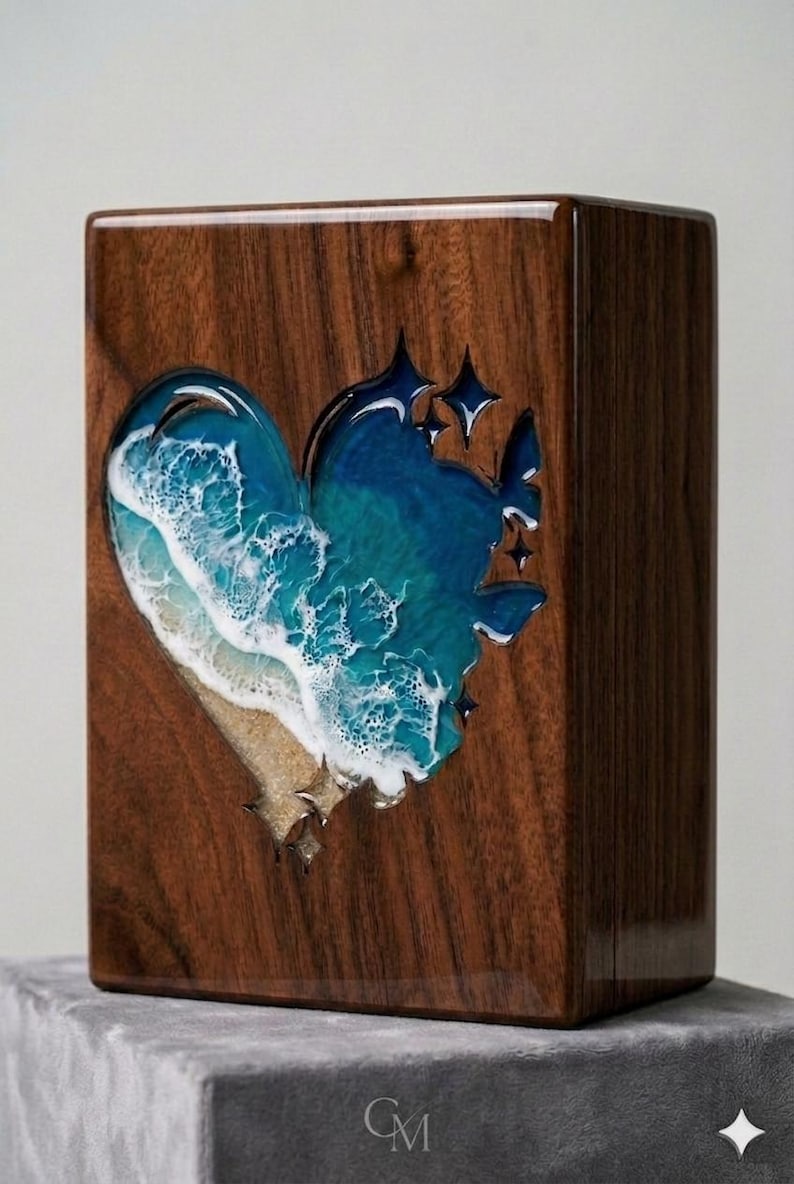 May include: A wooden box with a heart-shaped cutout filled with a resin ocean scene. The resin art depicts a beach with waves and stars. The box is made of dark wood and has a glossy finish.