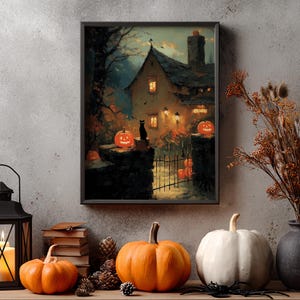 May include: A framed Halloween-themed print depicts a spooky cottage scene with jack-o'-lanterns, a black cat, and a wrought iron gate. The print is displayed on a shelf with pumpkins, a lantern, and dried foliage, creating a festive autumn display.
