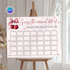May include: A white sign on a wooden easel with the text "Guess the arrival date of BABYROBERTSON." The sign has a calendar grid with days of the week and dates. Decorative elements include cherries and hearts. The words "Edit & Print" are also visible.