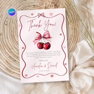 Puede incluir: Una tarjeta de agradecimiento rosa y blanca con un diseño de cereza y lazo en acuarela. La tarjeta incluye el texto "Thank You!" y un mensaje personalizado, con los nombres Amelia & David y la fecha 12 de junio de 20XX.