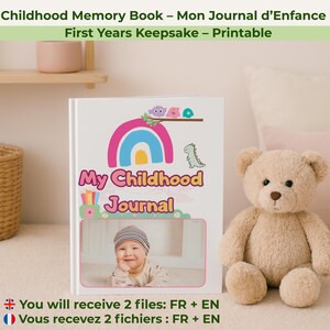 Peut inclure: Un livre blanc "My Childhood Journal" avec une illustration d'arc-en-ciel et de dinosaure. La couverture présente une photo de bébé. Un ours en peluche beige est à droite du livre. Le texte sur la couverture indique "Childhood Memory Book - Mon Journal d'Enfance".